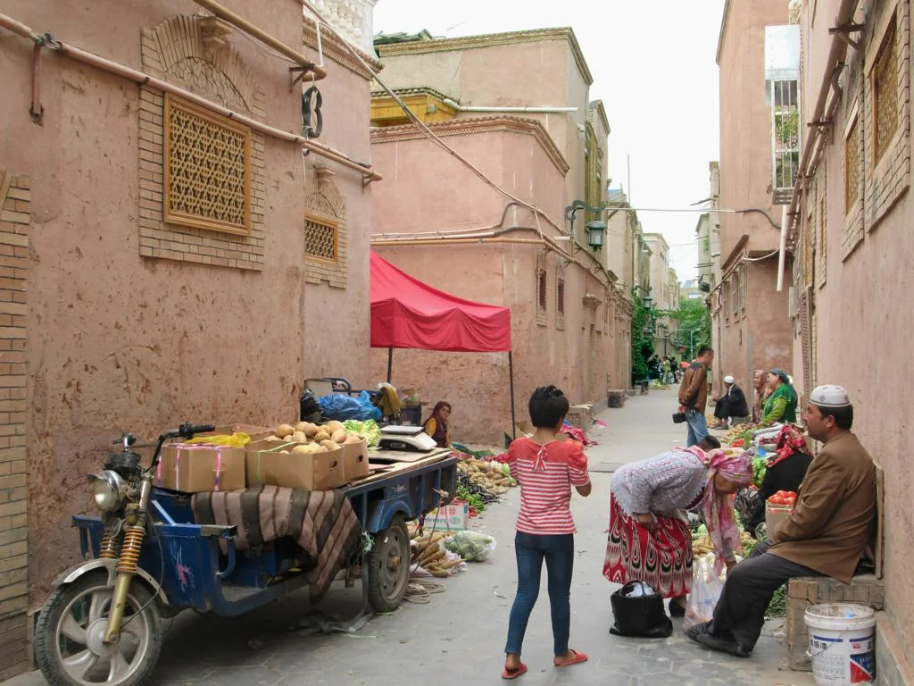 Everyday trade on a back street in the ancient city of Kashgar. The lane remains a place of residence, movement and work.