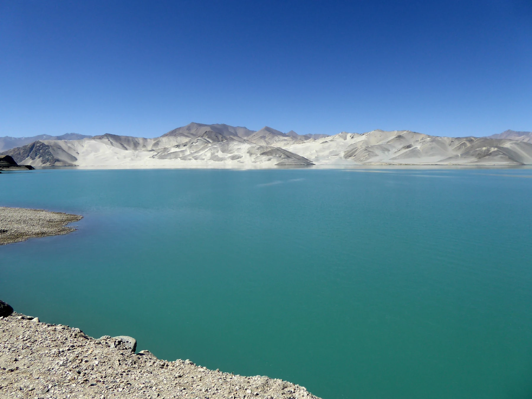 Baisha Lake and pale mountain slopes near Bulunkou