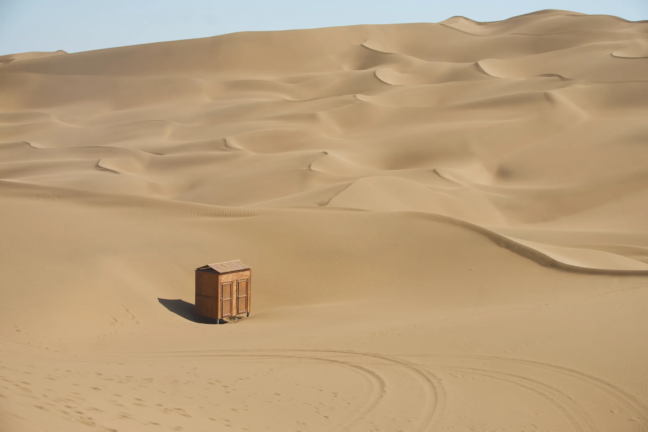 A small hut among shifting dunes in the Kumtag Desert, Xinjiang